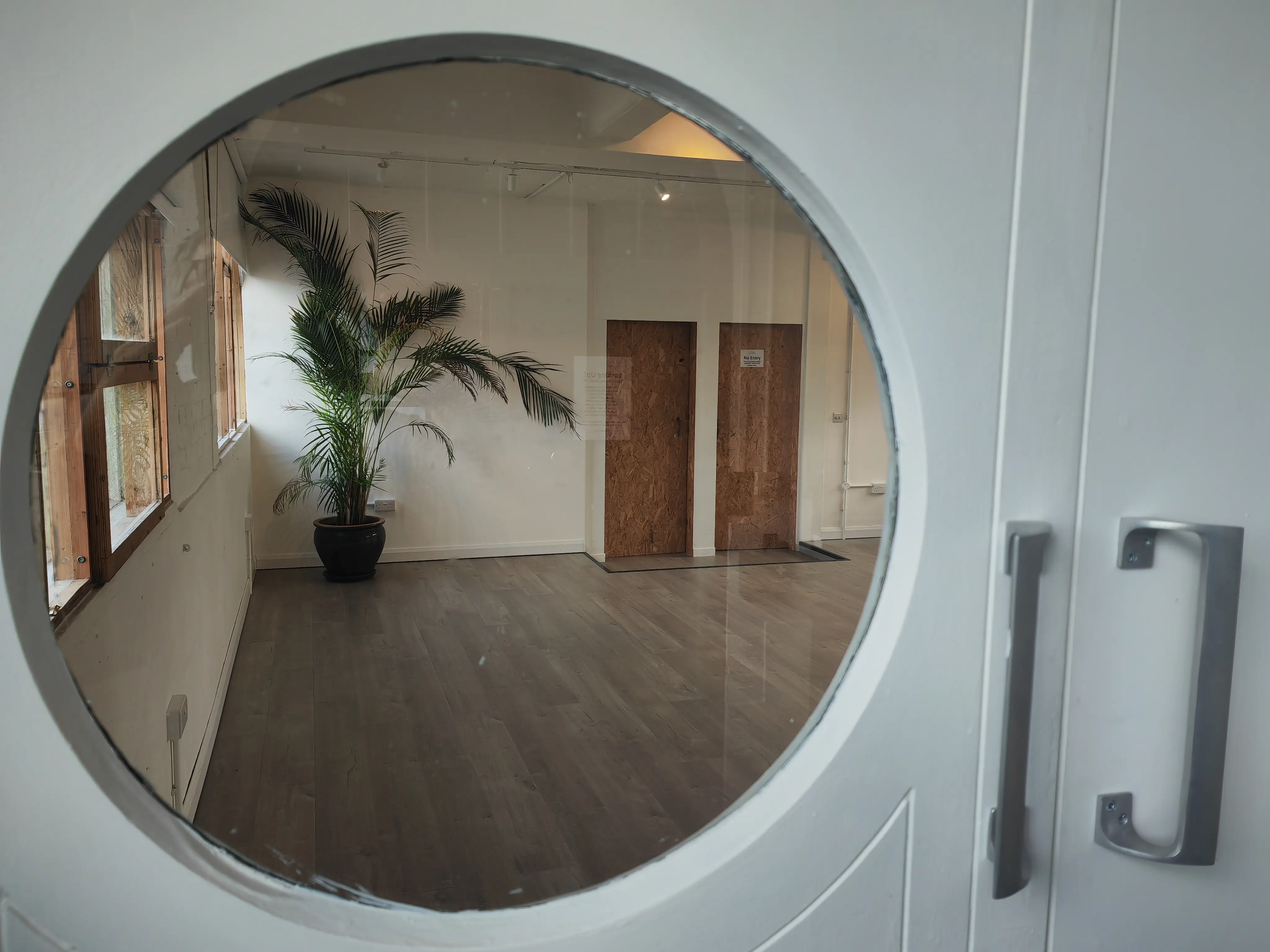 Circle window looking into Studio 49 — the converted Victorian warehouse on Pixley Street